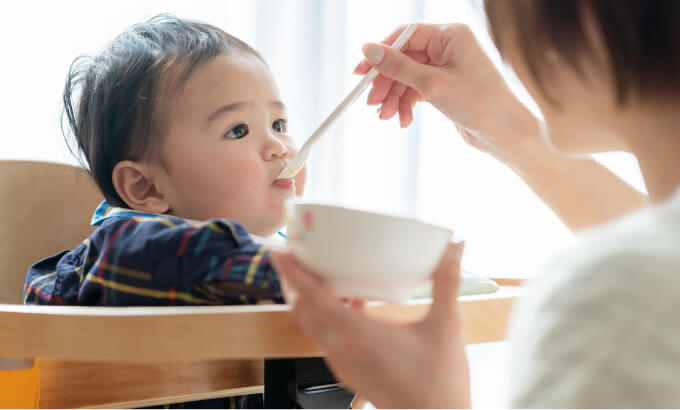 赤ちゃんにご飯を食べさせている写真